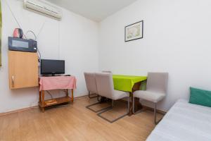 a room with a table and chairs and a television at Apartments with parking space Marusici, Omis - 954 in Mimice