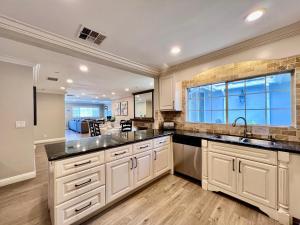 アナハイムにあるStunning 8 bedroom 6 bathroom Pool Homeの白いキャビネットと大きな窓のあるキッチン