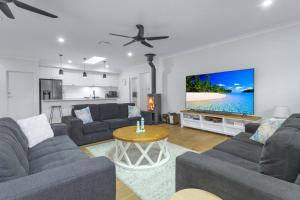a living room with two couches and a tv at Bikinis & Martinis in Vincentia
