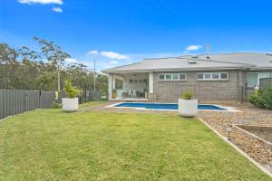 a house with a swimming pool in a yard at Bikinis & Martinis in Vincentia