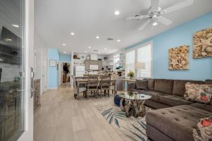 ein Wohnzimmer und eine Küche mit einer Couch und einem Tisch in der Unterkunft Sea Glass Cottage - Beach Gear Credit Included! in Port Aransas