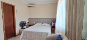 a bedroom with a bed and a chair and a window at Cop 30 - Casa em Condominio Oasis in Ananindeua +30 photos