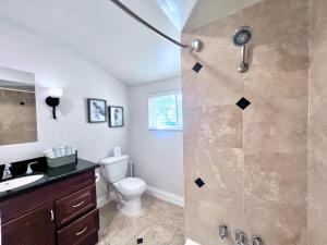 a bathroom with a shower with a toilet and a sink at Cute 3 bedroom 2 bath home near Convention Center & Disney in Anaheim +16 photos