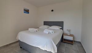 una camera da letto con un letto bianco con asciugamani sopra di Casa Fadiju a Lecci Altre 7 foto