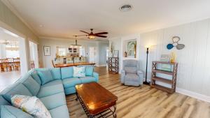 a living room with a blue couch and a table at Recently Updated Home w/ Private Pier/Boat Slip in Orange Beach