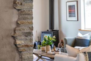Una sala de estar con un sofá y una chimenea. en Stone Cottage, en Arrowtown