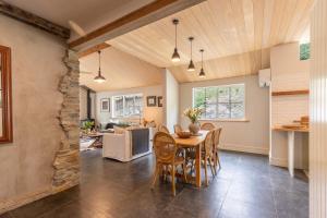 Un comedor y una sala de estar con mesa y sillas. en Stone Cottage, en Arrowtown