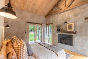 Un dormitorio con una cama y una chimenea. en Stone Cottage, en Arrowtown
