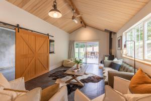una sala de estar con una gran puerta corredera de granero en Stone Cottage, en Arrowtown 14 fotos más
