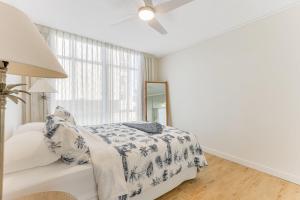 a white bedroom with a bed and a mirror at Beach Lodge Unit 5 in Gold Coast