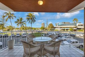 a balcony with a table and chairs and a parking lot at Beach Lodge Unit 5 in Gold Coast