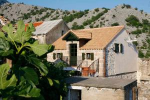 a brick house with a mountain in the background at Holiday home in Starigrad-Paklenica 41708 in Starigrad-Paklenica