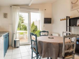 une cuisine avec une table et des chaises ainsi qu'une fenêtre dans l'établissement Gîte indépendant avec terrasse - Proche de St Nazaire et La Baule, au cœur du Parc de Brière - FR-1-306-862, à Saint-Malo-de-Guersac