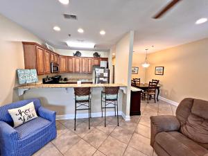 a kitchen and living room with a counter and chairs at Laguna Breeze in Gulf Shores