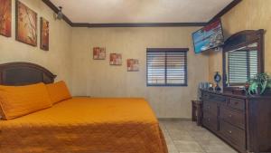 a bedroom with a bed and a dresser and a television at Sonoran Sky in Puerto Peñasco