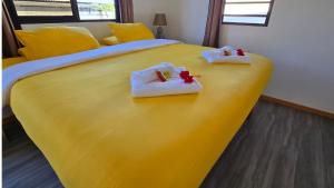 a yellow bed with two babies in towels on it at Tahiti Kalihi Lodge in Faremi