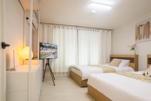 a bedroom with two beds and a television in it at Inn Seoul - Private and Cozy home in Bongcheon in Seoul