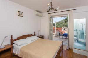 1 dormitorio con 1 cama y puerta corredera de cristal en Apartment and Rooms Zora, en Dubrovnik