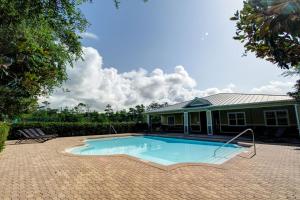 una piscina frente a una casa en Four C's Retreat - Lavish Home with Private Boardwalk Access to the Beach, en Blue Mountain Beach