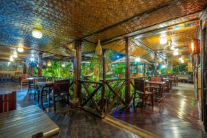 a restaurant with tables and chairs and a wall with plants at Puerto Pension Inn in Puerto Princesa City