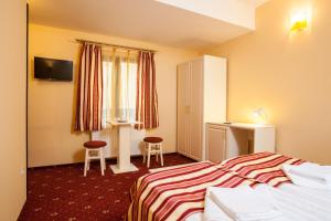 Cette chambre comprend un lit et un bureau. dans l'établissement Extravagance Hotel, à Sighişoara