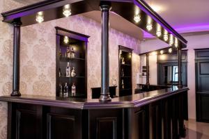 a bar in a room with purple lighting at Extravagance Hotel in Sighişoara