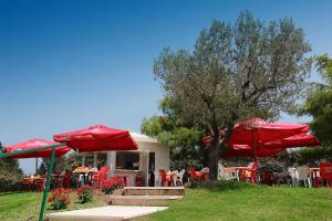 a group of tables and chairs with red umbrellas at Mobilehomes in Sirmione - Gardasee 22177 in Sirmione +14 photos