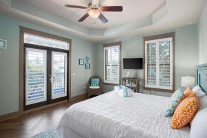 1 dormitorio con 1 cama, ventilador de techo y ventanas en Four C's Retreat - Lavish Home with Private Boardwalk Access to the Beach, en Blue Mountain Beach 49 fotos más