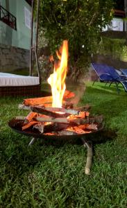 a barbecue grill with flames in the grass at Pousada Gipoia in Angra dos Reis +16 photos