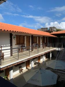 a resort with a pool and tables and umbrellas at Pousada Luz do Sol in Porto Seguro