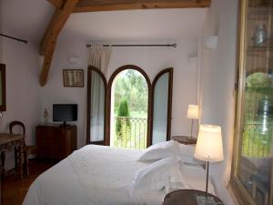 a bedroom with a bed and a large window at La Ferme Rose-Hôtel de Charme in Moustiers-Sainte-Marie +23 photos