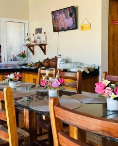 a dining room with tables and chairs with flowers on them at Pousada Zoom Jericoacoara in Jericoacoara