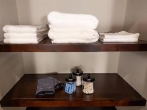a shelf with towels and a pile of towels at Your Family’s Home Away from Home w/ No Extra Fees in Broken Arrow +71 photos