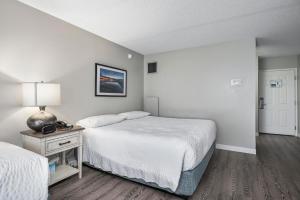 a bedroom with two beds and a table with a lamp at First Floor Standard Deluxe King in North East