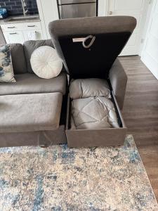 Una caja de cartón tirada en el suelo junto a un sofá. en Peaceful Pad on Peters, en Atlanta