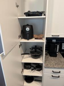 a kitchen pantry with white shelves and a pans at Peaceful Pad on Peters in Atlanta