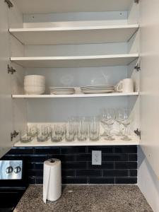 a kitchen with empty wine glasses on shelves at Peaceful Pad on Peters in Atlanta +26 photos