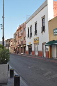 an empty street in a town with buildings at Hotel San Carlos in Irapuato