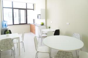 a dining room with white tables and chairs at Manolia City Residences in Nicosia