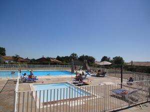 a group of people sitting around a swimming pool at Villa in France with Garden & Barbecue in Les Forges