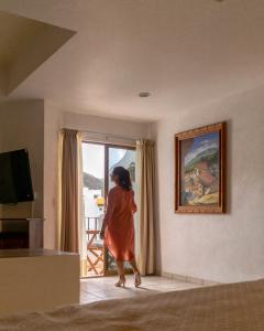 a woman walking into a room with a painting at Casa Olas in Puerto Vallarta