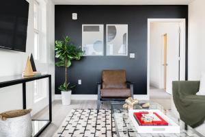 a living room with black walls and a chair at Serenity in Style | Espadin LoHi in Denver