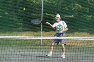 un hombre balanceando una raqueta de tenis en una pelota de tenis en Top Floor East Handicap Accessible, en North East