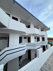 a white building with white balconies on it at Kitnet Praia Grande in Arraial do Cabo