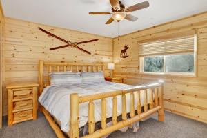 Blockhausschlafzimmer mit einem Bett und einem Deckenventilator in der Unterkunft Skyline lodge #2353 in Big Bear Lake