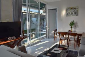a living room with a couch and a table and a television at Aroha Villa in Banjar