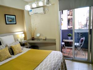 ein Schlafzimmer mit einem Bett und einem Balkon in der Unterkunft Bello Departamento 2 Habitaciones, Barrio Norte in San Miguel de Tucumán + 42 Fotos