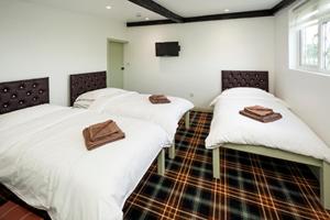two beds in a room with white sheets at King William in Luton