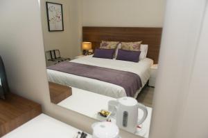 widok na sypialnię z łóżkiem i lustrem w obiekcie Manolia City Residences w Nikozji