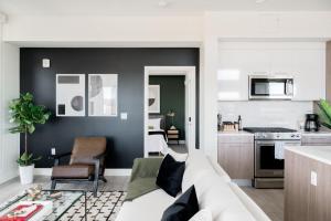 a living room with a white couch and a kitchen at Serenity in Style | Espadin LoHi in Denver